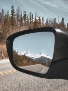 A beautiful reflection of a mountain in a side mirror of a car
